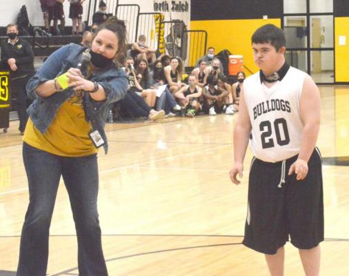 Bryce Lide prepares to shoot five shots in an attempt to raise money for the North Zulch basketball program Friday as part of their Shoot-athon fundraiser. (Also pictured: North Zulch Coach Melissa Padgett, who emceed the halftime event) CAMPBELL ATKINS