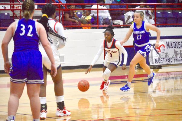 Kayla Ford dribbles between defenders during Madisonville’s 49-24 win over Robinson at MHS Monday. CAMPBELL ATKINS