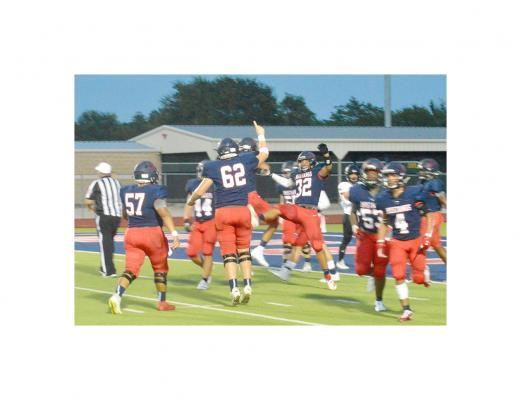Football 3 pic: Cameron Thrower (32) celebrates with teammates after scoring a defensive touchdown to tie the game in the first quarter Friday. CAMPBELL ATKINS
