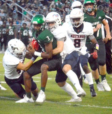A host of Mustang defenders stand up a Livingston ball carrier Friday. PHOTO BY CAMPBELL ATKINS