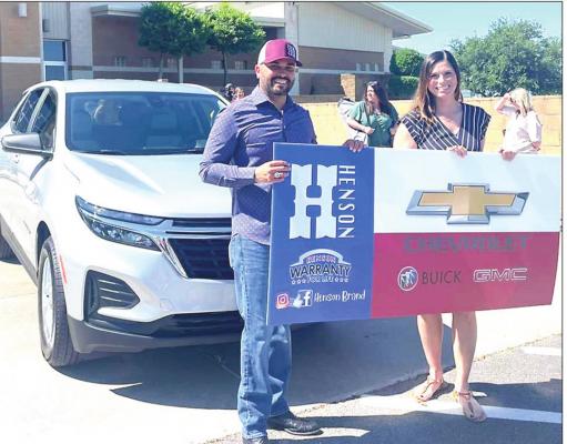 Erica Blakley is presented with a two-year lease on a 2022 Chevrolet Equinox by Henson Managing Partner Eric Barbosa as an award for winner MCISD Teacher of the Year.