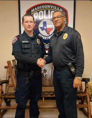 Patrol Sgt. Dustin Brisher (left) shakes hands with Madisonville Police Chief Herbert Gilbert after his promotion Thursday, Jan. 23. Brisher received the Exceptional Police Service Award in December. COURTESY PHOTO