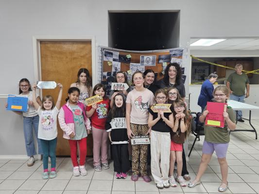 Members of Girl Scout Troop #9504 pose with props after completing a mystery activity Friday, Jan. 9. The scouts solved puzzles and followed clues to find a missing cookie recipe ahead of cookie season, which begins Wednesday, Jan. 14. PHOTOS COURTESY OF TIFFANY MCCLURE