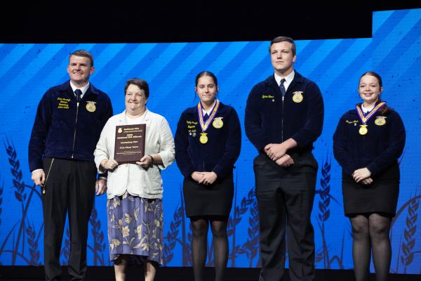 National FFA Secretary Luke Jennings (left), Madisonville FFA advisor Lynita Foster, and marketing plan team members Hadley Bridges, Bynum Starr and Harper Nash celebrate their first-place finish at the 98th National FFA Convention &amp; Expo Oct. 31 at Lucas Oil Stadium in Indianapolis. COURTESY PHOTO
