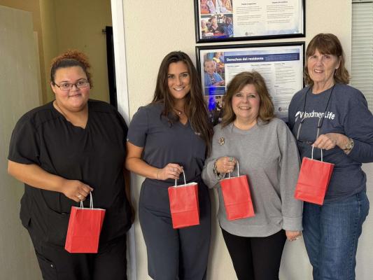 WoodmenLife Chapter 4647 members delivered 65 care packages containing Christmas socks, snacks and lotion to seniors at Riverwood Healthcare on Bacon Street on Nov. 6. Pictured from left are two Riverwood Healthcare aides, WoodmenLife Chapter 4647 Secretary Dee Barnes and WoodmenLife Customer Service Representative Lois Milstead. The donation was part of the chapter's quarterly Common Bond activity. COURTESY PHOTO