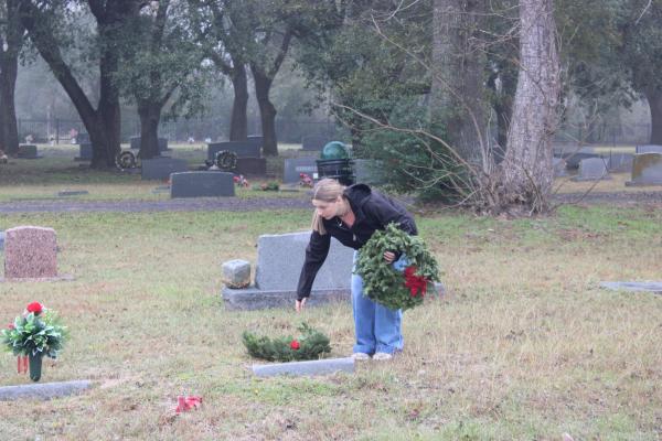 Alex Mooney, an 11th grade North Zulch FFA member, places a wreath on a veteran's grave in Madisonville Cemetery Dec. 13 for Wreaths Across America. METEOR PHOTOS BY RICHARD SIRMAN