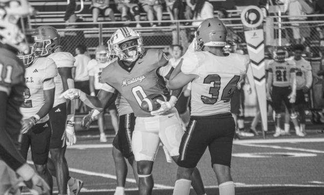 Madisonville Mustangs' Phillip Green (0) rushes between Diboll defenders during Friday night's season opener at Mustang Stadium. Green led the Mustangs with 153 yards rushing and two touchdowns in their 28-27 victory over the Lumberjacks. METEOR PHOTOS BY RICHARD SIRMAN
