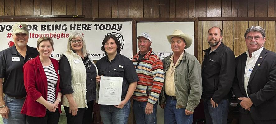 Garrett Riddler and his American Red Cross Lifesaving Award - Certificate of Extraordinary Personal Action - surrounded by Heart of Texas Executive Director Jennifer Young, along with board members Rick Kattner and Pamela Smits, and Madison County Judge Clark Osborne and Madison County commissioners Kenneth Starr, Carl Wiseman, and David Porhosk. COURTESY PHOTO