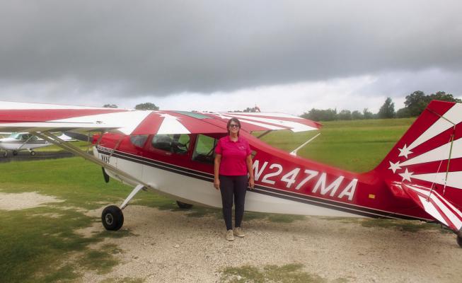 Wanda Collins stands with the Super Decathlon her flight school uses for aerobatic training at Madisonville Municipal Airport. Collins founded The Lazy 8 Flight School and flew air shows before her airline career. METEOR PHOTO BY RICHARD SIRMAN