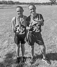 North Zulch Bulldog cross country runners showcase their medals and team spirit at the Madisonville meet. Junior high medalists Alyssa and Kylie Lawson. The combined North Zulch cross country squad poses together after competing against 3A and 4A schools in their season opener. COURTESY PHOTOS