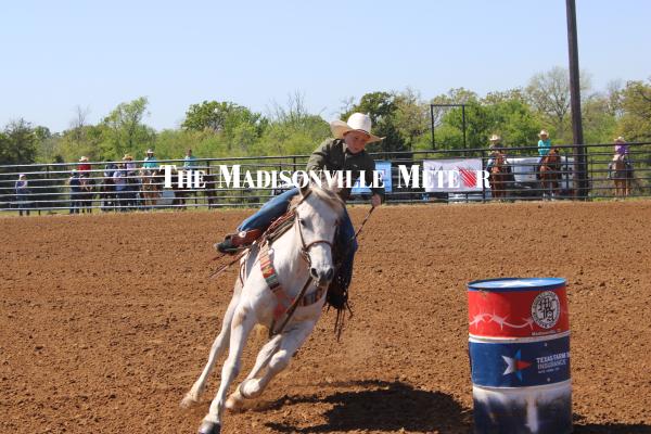 A young barrel racer leans into a turn during the Madison County Fair Association youth rodeo Saturday, March 21, at the Madison County Fairgrounds in Madisonville. METEOR PHOTO BY RICHARD SIRMAN