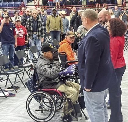 During the Veterans Day program, Burke Landry, a World War II veteran, receives a salute at Mustang Gym Friday, Nov. 10. In recognition of his service, Landry is presented with a United States Flag. The event also paid tribute to each branch of the army. METEOR PHOTOS BY RICHARD SIRMAN