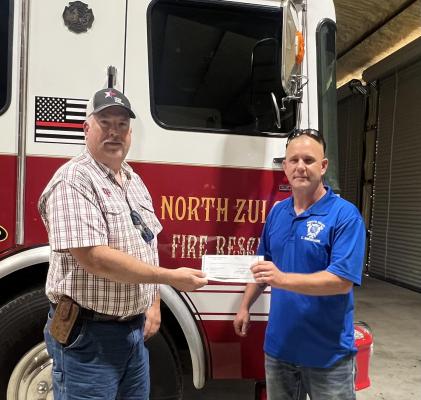 Kevin Counsil, board president of Madison County Farm Bureau, presents a $500 donation check to North Zulch Volunteer Fire Department Chief Chuck Wiedecker. This donation completes the Farm Bureau’s support of volunteer fire departments in the area. COURTESY PHOTO