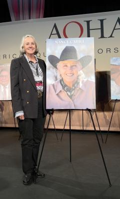 Nancy Cahill stands next to her portrait during the American Quarter Horse Hall of Fame announcement ceremony. Cahill, an AQHA Honorary Vice President with 50 years in the industry, was recognized for her contributions to quarter horse training, youth development and animal welfare advocacy. COURTESY PHOTO