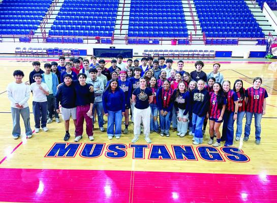 The Madisonville High School boys and girls soccer teams gather at midcourt in the Mustang competition gym before heading to face their respective district opponents last week. COURTESY PHOTO