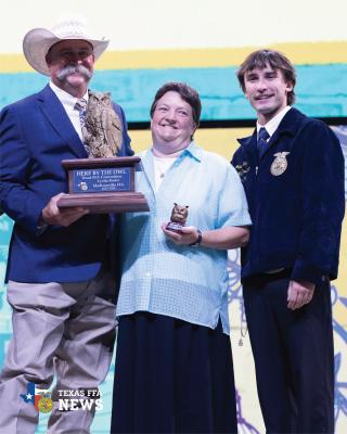 Madisonville FFA advisor Lynita Foster holds the Here by the Owl Educator of the Year Award during the final general session of the 98th Annual Texas FFA Convention.
