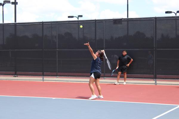 Tennis player serves at first practice