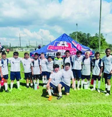 The Elite Boys FC Mustangs soccer team poses for a group photo under their blue tent after their dominant 7-1 victory on Sunday, Sep. 22. COURTESY PHOTO