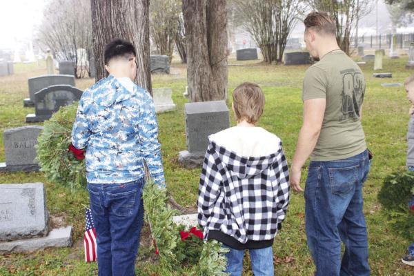 Volunteers from the Madisonville Cemetery Association and American Legion Austin Reed Post No. 84 prepare wreaths for veterans’ graves alongside North Zulch FFA members Saturday, Dec. 13, at Madisonville Cemetery. Madison County Judge Clark Osborne leads the annual Wreaths Across America event in Madisonville. METEOR PHOTOS BY RICHARD SIRMAN