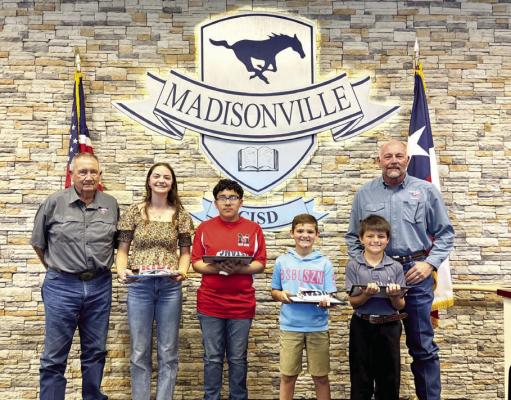 Students of the Month pose with retiring MCISD trustees Dennis McWhorter (left) and Greg McBee (right) at the Monday, May 12, school board meeting. Those students include Presley Ringo (second from left) from Madisonville High School, Karol Almanza (center) from Madisonville Junior High, Cantyn Kelley from the intermediate campus, and Paxton Jarrel from the elementary school. COURTESY PHOTO