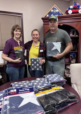 Lois Milstead (left), Erica Greene and Kevin Counsil display U.S. and Texas flags donated by Woodmen Life Chapter 4647 to Madison County Veterans Services. The chapter purchased the flags through the H.E.A.R.T.S. If any residents want a U.S or Texas Flag stop by the Veterans Service office in the county courthouse annex. 