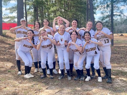 The Lady Bulldogs posing with a picture of Denise Hanson, the late mother of player Mckenna Hanson, at the tournament's conclusion. COURTESY PHOTO