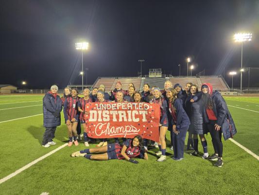 The Madisonville High School Lady Mustangs celebrate their undefeated District 16-4A championship at Mustang Stadium after beating Palestine 2-1 March 16. The two teams shared the district title last year.