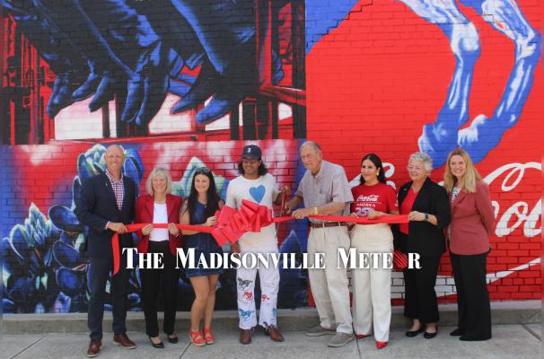 Aaron Rogers (left), Tammy Hoke, Shelby Stallings, Gabriel Portillo, Mayor Bill Parten, Ada Ortega, Tracy Bennett Viramontes and Kelcey Young cut the ribbon on the new Coca-Cola mural at 101 W. Trinity St. June 22. PHOTO BY RICHARD SIRMAN
