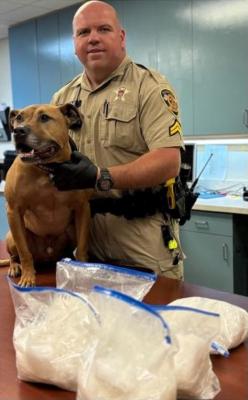 Cpl. McIntyre and K-9 Maverick with the confiscated 11 pounds of meth.