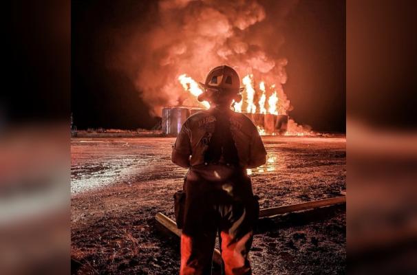 A firefighter watches flames rise from condensate tanks during an oil well fire on FM 1452 West May 21. PHOTOS COURTESY OF NORTH ZULCH VOLUNTEER FIRE DEPARTMENT