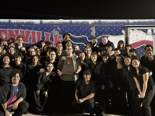 Madisonville High School Mustang Band director Stephanie Schmidt holds the University Interscholastic League Sweepstakes trophy as band members gather around Wednesday, March 4, after the UIL concert and sight-reading evaluation in Bastrop. The Mustangs secured the Sweepstakes award for earning a Division 1 rating in both fields of competition. COURTESY PHOTO