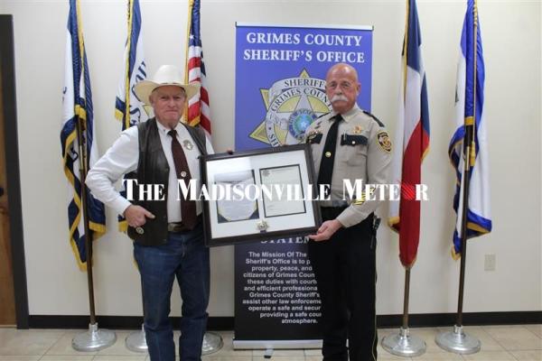 Grimes County Sheriff Don Sowell (left) presents Madison County Chief Deputy Curtis Klingle with a Peace Officer’s Purple Heart at the Grimes County Sheriff’s Office April 10. METEOR PHOTO BY MATTHEW YBARRA