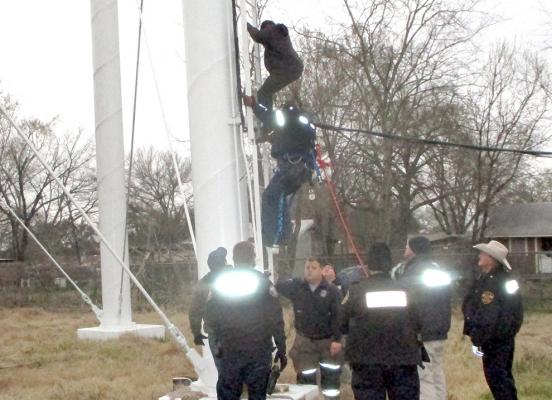 A 17-year-old is escorted down the water tower on Washington Street Friday by MVFD Chief Thom Jones after he climbed 90 feet up the 135-foot structure. JONATHAN DEELEY