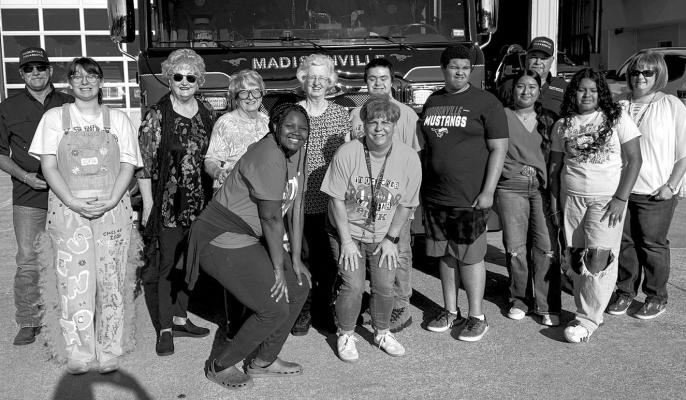 Madisonville Fire Chief Thom Jones (far left) stands with Stang Gang members and Daughters of the American Revolution representatives in front of a Madisonville Volunteer Fire Department engine Oct. 10. The groups delivered snacks and water as part of DAR’s annual Day of Service honoring first responders.