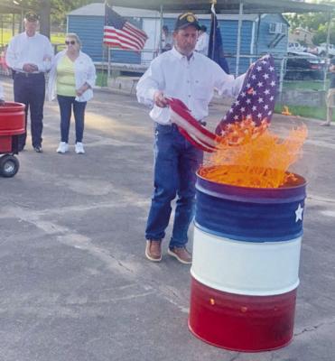 Carl Ramsey, 1st Vice of the Sons of the Legion, places a worn American flag into the retirement fire during the Austin Reed American Legion Post 84 Flag Retirement Ceremony on Saturday, June 14. See more phots on page 12. COURTESY PHOTO