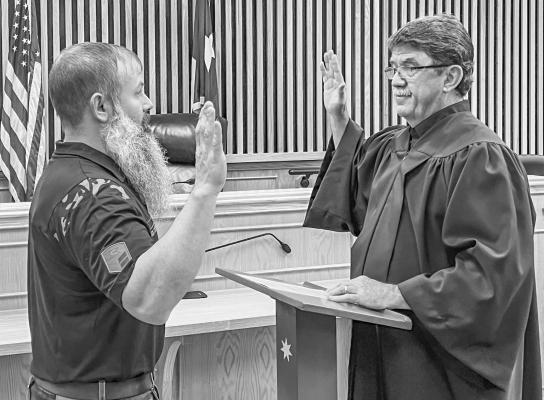 Daniel Bracewell (left) being sworn in by Judge Osborne (right) at the county courtroom in Madisonville.