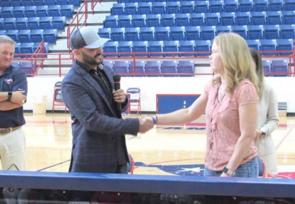 Henson Brand Operating Partner Eric Barbosa shakes hands with MHS math teacher Amy Clary, who was voted the districts’ top educator for the 2020-21 school year, earning her a two-year lease on one of three Henson vehicles of her choice. PHOTO BY CAMPBELL ATKINS