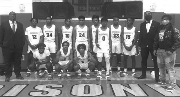 The Madisonville basketball team poses together at MHS following their 52-37 win over Robinson to open district. CAMPBELL ATKINS
