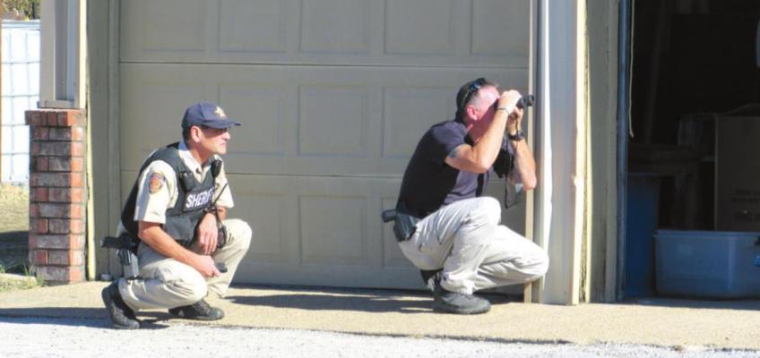 Madison County Sheriff’s Deputy Ashley Kishino (left) and Madisonville Police Department Captain Richard Morris conduct a perimeter search of American Glass &amp; Mirror Dec. 9 after an individual phoned in a bomb threat to the May Street establishment. Campbell Atkins