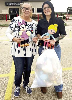 A Heart and Hands Family Care Center representative (left) and Carly Foster of the Madison County Sheriff’s Office hold stuffed animals donated to the department. Deputies will give the toys to children during calls. PHOTO COURTESY OF MADISON COUNTY SHERIFF’S OFFICE