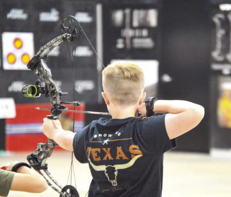 Eli Ellis prepping his bow getting ready to shoot at the target.