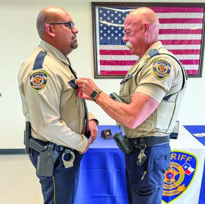 Deputy Aurelio Cuevas receives the Medal of Valor from Chief Deputy Curtis Klingle for his bravery in helping save three people from a burning vehicle on Interstate 4 5.