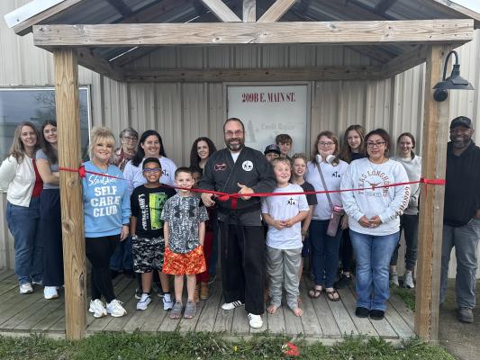 Justin Kiehl (center) celebrates with his family, students, parents, and supporters after cutting the ribbon Monday, Jan 5, at Crossover Martial Arts, 209B E Main St. The faith-based dojo marks Kiehl’s second location after opening his first school in Leona two years ago.