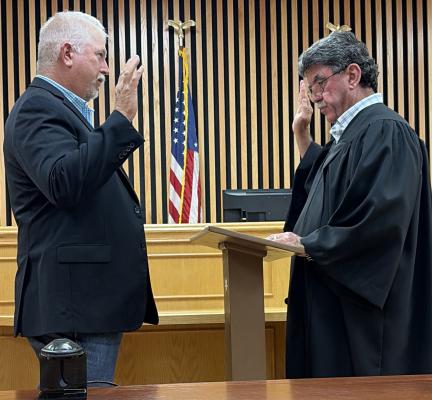 Kevin Counsil (left) takes the oath of office from Madison County Judge Clark Osborne on Tuesday, May 5, as he is sworn in as justice of the peace, Precinct 1. Counsil will fill the unexpired terms of Jon Stevens, who stepped down after years of service.