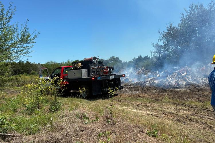 A North Zulch Volunteer Fire Department brush truck holds the line at Willowhole Cemetery on Tuesday. The department dispatched four brush trucks and a firefighter’s front-end loader to the scene.