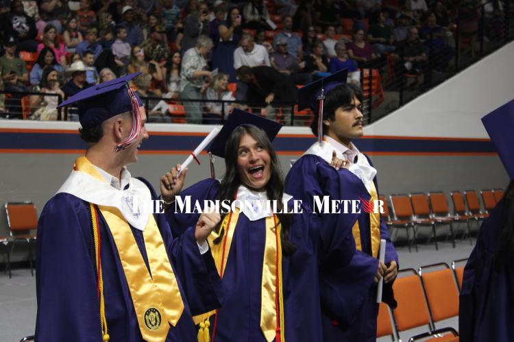 Jacqueline Zavala, center, reacts with tears and laughter after receiving her diploma alongside classmates Jackson Zanolini, left, and Joel Zavala Thursday during Madisonville High School’s commencement ceremony at the Bernard G. Johnson Coliseum in Huntsville. 