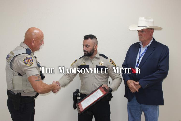 Chief Deputy Curtis Klingle, left, shakes hands with Sgt. Koray Elkat. Elkat pulled the man back to safety.