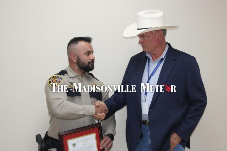 Sgt. Koray Elkat, left, shakes hands with Sheriff Bobby Adams after receiving a Life Saving Award.
