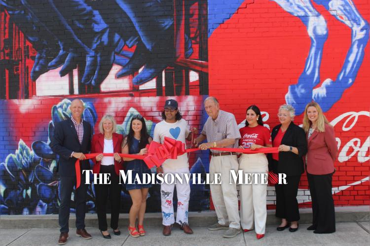 Aaron Rogers (left), Tammy Hoke, Shelby Stallings, Gabriel Portillo, Mayor Bill Parten, Ada Ortega, Tracy Bennett Viramontes and Kelcey Young cut the ribbon on the new Coca-Cola mural at 101 W. Trinity St. June 22. PHOTO BY RICHARD SIRMAN
