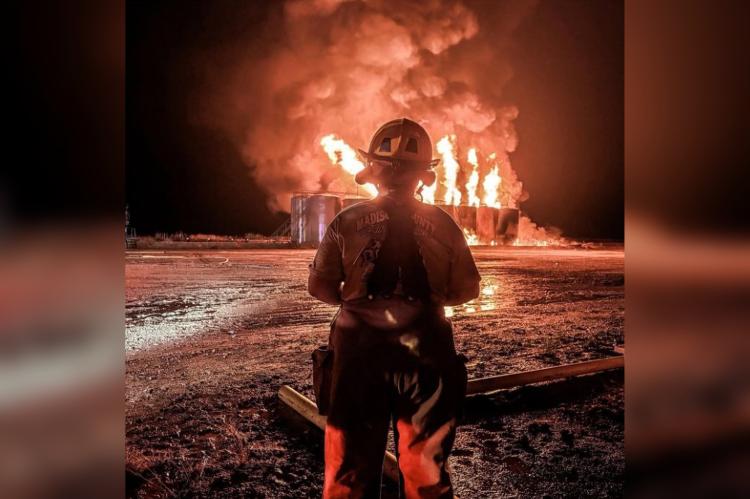A firefighter watches flames rise from condensate tanks during an oil well fire on FM 1452 West May 21. PHOTOS COURTESY OF NORTH ZULCH VOLUNTEER FIRE DEPARTMENT
